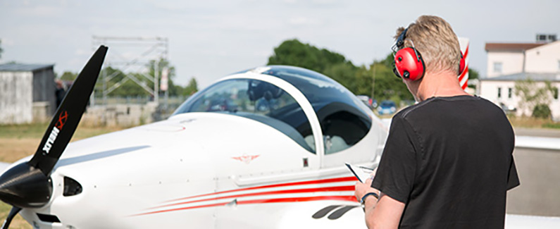 Mann trägt einen Gehörschutz auf dem Flugfeld
