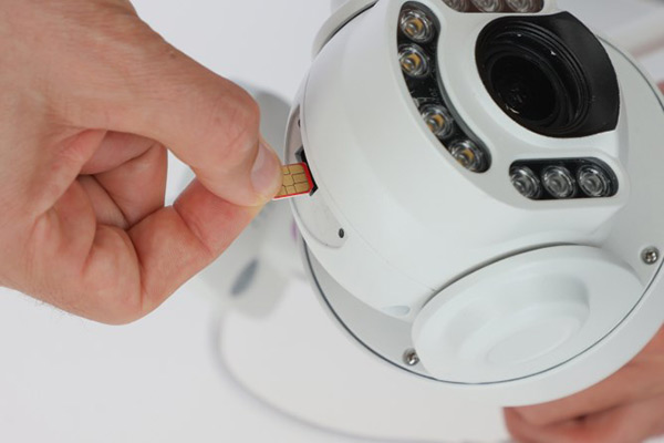 Ein Mann steckt eine SIM Karte in die brandneue 4G Kamera IPCAM SIM FHD von Kerbl