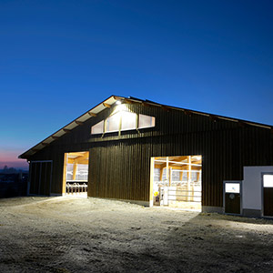 Ein mit LED Beleuchtung erhelltes landwirtschaftliches Gebäude am Abend