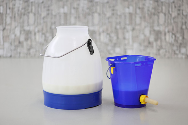 Ein Melkeimer und ein Tränkeeimer gefüllt mich Milch