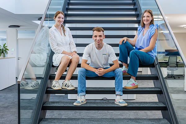 Drei Auszubildende von Kerbl sitzen auf einer Treppe