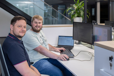 Zwei Kerbl Mitarbeiter arbeiten gemeinsam am Schreibtisch mit Computer und Laptop