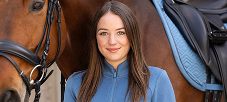 Eine Reiterin und ihr braunes Pferd in hellblauer Reitbekleidung von Covalliero